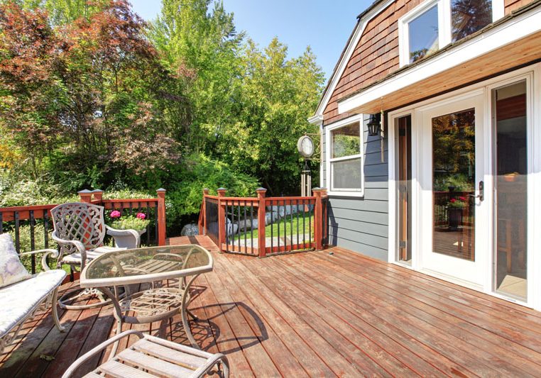 House exterior with large open deck and outdoor furniture.